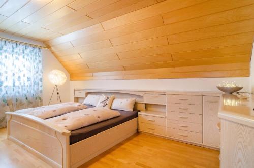 uma cama num quarto com tecto em madeira em Schwarzwalduhren Nescht Triberg em Triberg