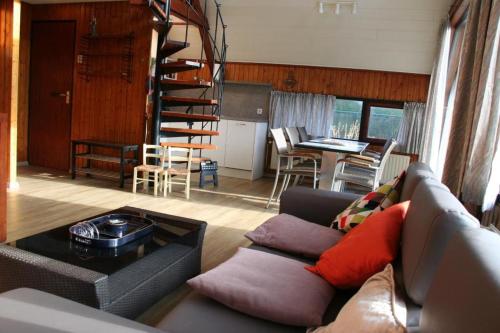 a living room with a couch and a spiral staircase at De Vlier 23 in Nieuwvliet