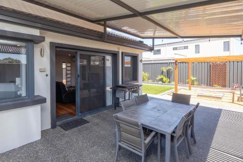 a patio with a table and chairs and a grill at Hollow Beach House - Bunbury in Bunbury