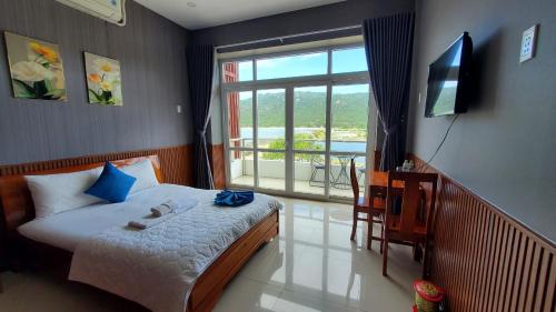 a bedroom with a bed and a television and a balcony at Khu du lịch Hang Rái - Ninh Thuận in Thôn Thái An
