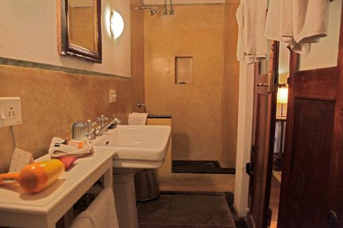 a bathroom with a white sink and a shower at Neemrana's - Bungalow on The Beach in Tarangambādi