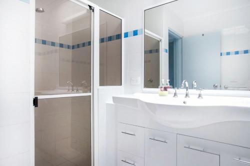 a white bathroom with two sinks and a shower at Perfectly Positioned Across From Mollymook Beach in Mollymook
