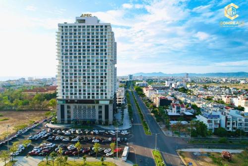 Apec mandala new Phú yên في توي هوا: مبنى طويل وبه سيارات متوقفة في موقف للسيارات