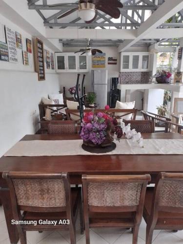 a dining room table with a vase of flowers on it at The Sangtus Home in Babakan Madang