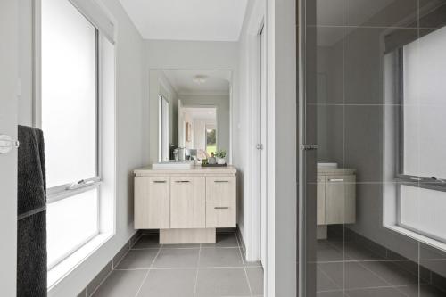 un baño con lavabo y espejo en Salt Breeze, en Cowes