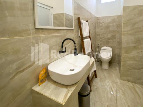 a bathroom with a white sink and a toilet at CBG INN RedPartner near Stasiun Solo Balapan in Kadiporo