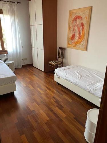 a bedroom with two beds and a wooden floor at Casa delle Rose - Appartamento Dagape in Marostica