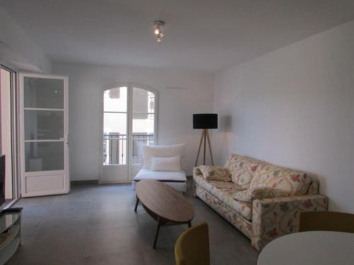 a living room with a couch and a table at New development Place des Lices in Saint-Tropez
