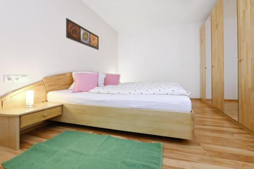 a bedroom with a wooden bed and a green rug at Chalet Keßler in Tschagguns