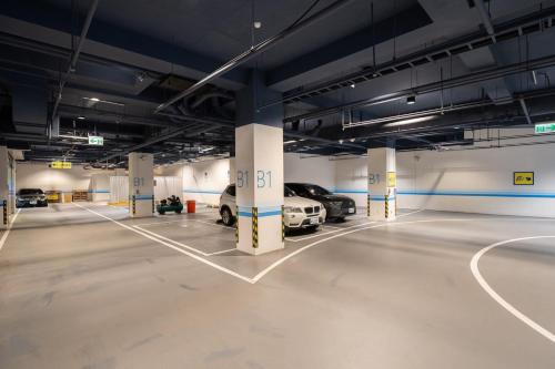 a parking garage with two cars parked in it at Guide Hotel Taichung Ziyou in Taichung