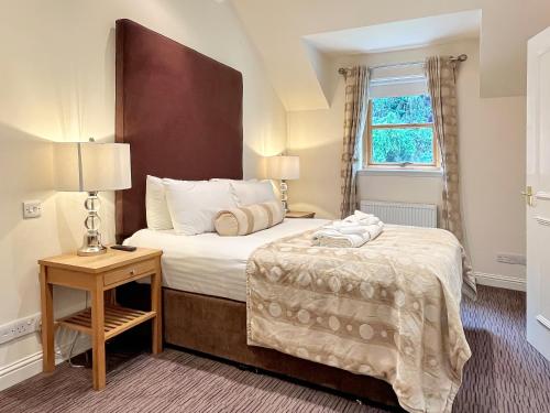 a hotel room with a bed and a table and a window at The Atholl Palace in Pitlochry