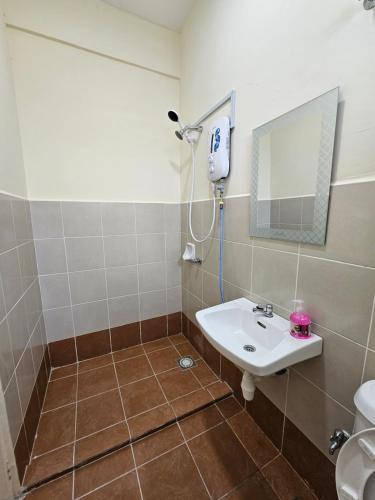 a bathroom with a sink and a mirror at Valerie Homestay in Sandakan