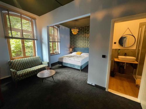 a bedroom with a bed and a chair and a sink at Agli Hotel in Norden