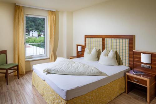 ein Hotelzimmer mit einem Bett und einem Fenster in der Unterkunft Apparthaus & Chalets Hofer in Zell am Ziller