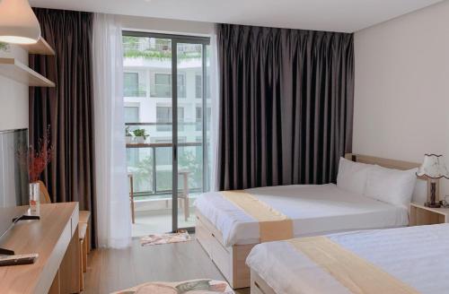 Apec mandala new Phú yên في توي هوا: غرفة فندقية بسريرين ونافذة