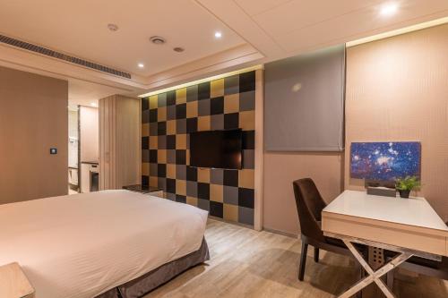 a bedroom with a bed and a desk and a computer at Guide Hotel Taichung Ziyou in Taichung