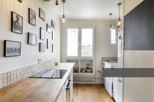 - une cuisine avec des murs blancs et un réfrigérateur blanc dans l'établissement En plein coeur de Levallois appartement de famille, à Levallois-Perret