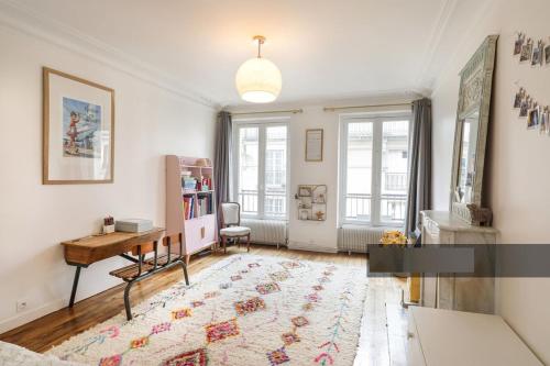 un salon avec une table et un bureau dans l'établissement En plein coeur de Levallois appartement de famille, à Levallois-Perret