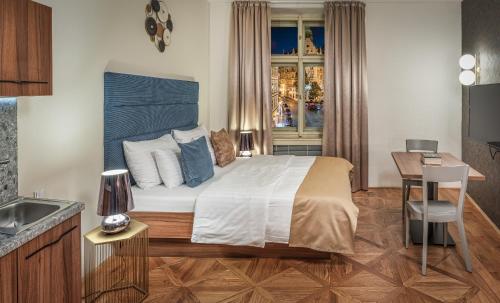 1 dormitorio con cama, escritorio y ventana en Golden Angel Suites by Adrez, en Praga