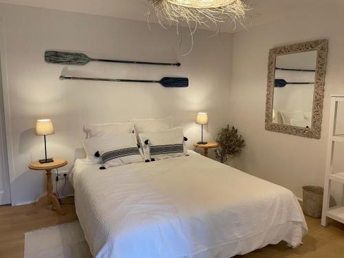 sypialnia z białym łóżkiem i lustrem w obiekcie Le Mas de Caroline w mieście Gargas