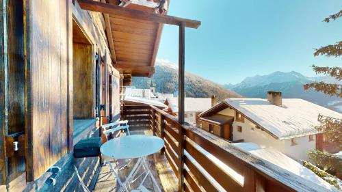 a balcony of a house with a table and chairs at Family chalet in the heart of the Val d'Anniviers in Saint-Luc