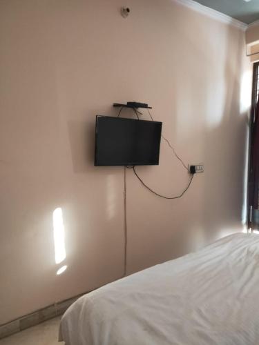 a flat screen tv on a wall in a bedroom at HOTEL CASTLE HOME STAY in Jaipur