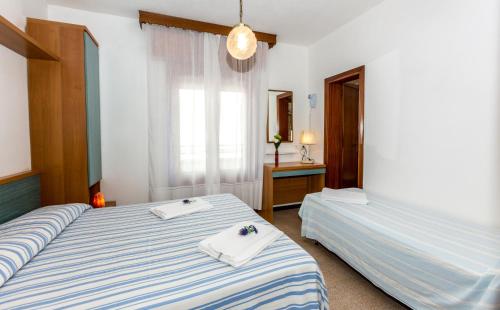 Un pat sau paturi într-o cameră la Hotel Saturno