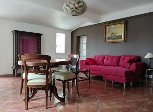 un salon avec un canapé rouge et une table dans l'établissement Superbe T3 avec terrasse en plein cœur du centre historique, à Aix-en-Provence