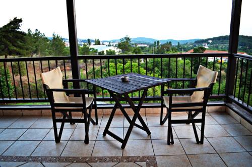 a wooden table and two chairs on a balcony at Archontariki Guesthouse in Poligiros