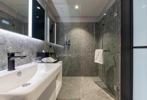 a bathroom with a sink and a shower at Travelodge Nimman in Chiang Mai