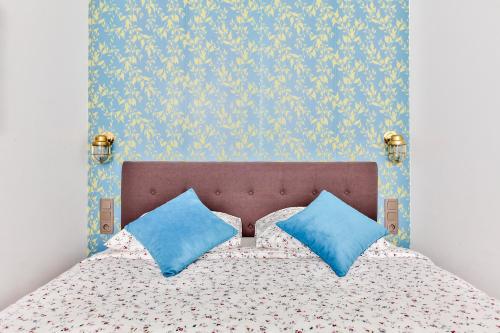 une chambre avec un lit avec des oreillers bleus dans l'établissement Suite Montorgueil, à Paris