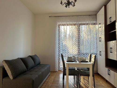 ein Wohnzimmer mit einem Sofa und einem Tisch in der Unterkunft Apartament Ludźmierska Nowy Targ in Nowy Targ