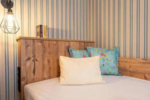 a bedroom with a bed with a wooden headboard and pillows at Hotel Krone Tirol in Reutte