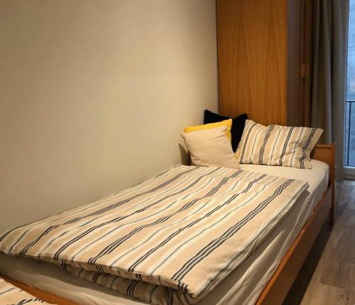 een bed met gestreepte lakens en kussens in een kamer bij appartement DE WATERLIJN in Knokke-Heist