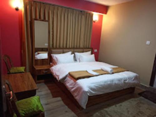 een slaapkamer met een groot bed en een spiegel bij Hotel Sai Kripa , Ravangla in Ravangla