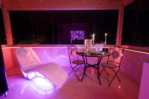 a table and chairs in a room with purple lights at B&B GRECALE Suite & Spa in Rende