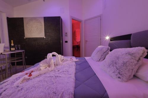 a purple bedroom with a large bed with purple lighting at B&B GRECALE Suite & Spa in Rende