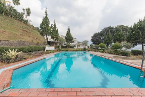 a large swimming pool with blue water at Urbanview Resort Anty Cisarua Tugu Puncak by RedDoorz in Sampal 2