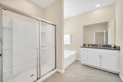 baño blanco con ducha y lavamanos en 7655 Oakmoss Loop, en Loughman