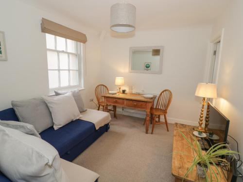 a living room with a blue couch and a table at 7A Lansdown Place Lane in Cheltenham