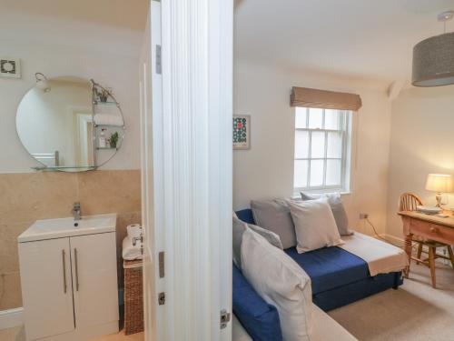 een woonkamer met een blauwe bank en een raam bij 7A Lansdown Place Lane in Cheltenham