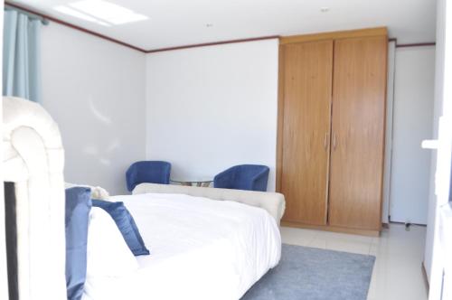 Habitación hospital con cama y armario de madera en BellMatt - Table Mountain and Ocean View Guests Suites, en Ciudad del Cabo
