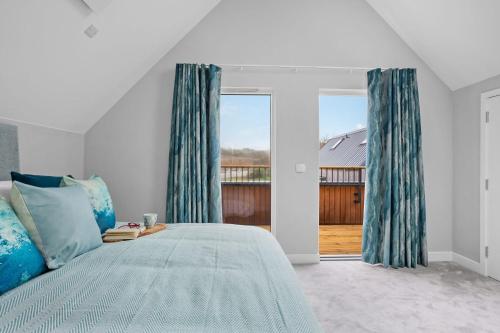 een slaapkamer met een bed en een groot raam bij No 2 The Vista, Willingcott, Woolacombe in Woolacombe