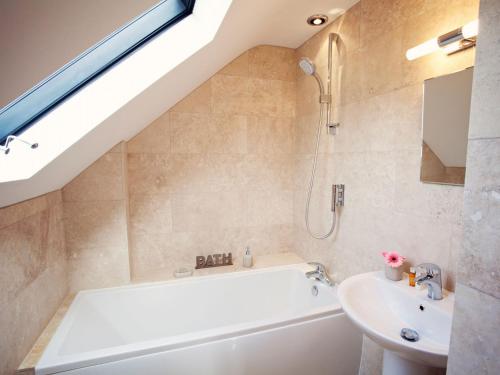 a bathroom with a bath tub and a sink at 2 Bed in Abergavenny 42909 in Mamhilad