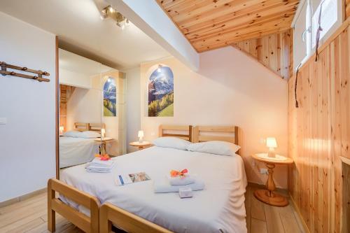 a bedroom with two beds in a room with wooden walls at La Tana Dell'Ermellino 3 Ski In Ski Out - Happy Rentals in Sestriere