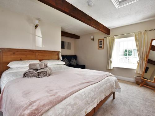 a bedroom with a large bed and a window at 2 Bed in Eyam PK812 in Eyam