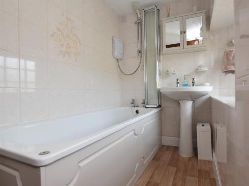 a white bathroom with a tub and a sink at 2 Bed in Eyam PK812 in Eyam