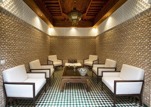 a waiting room with white chairs and a table at Riad Atrium & Spa in Marrakesh