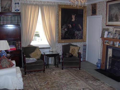 a living room with two chairs and a fireplace at The Old School House Mordington in Mordington