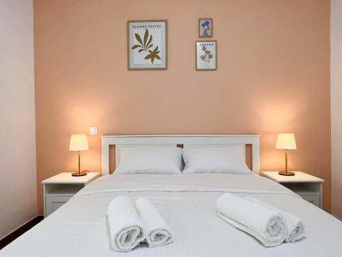 Un dormitorio con una cama blanca con toallas. en 3 Bedroom Apartment Near Flisvos, en Atenas